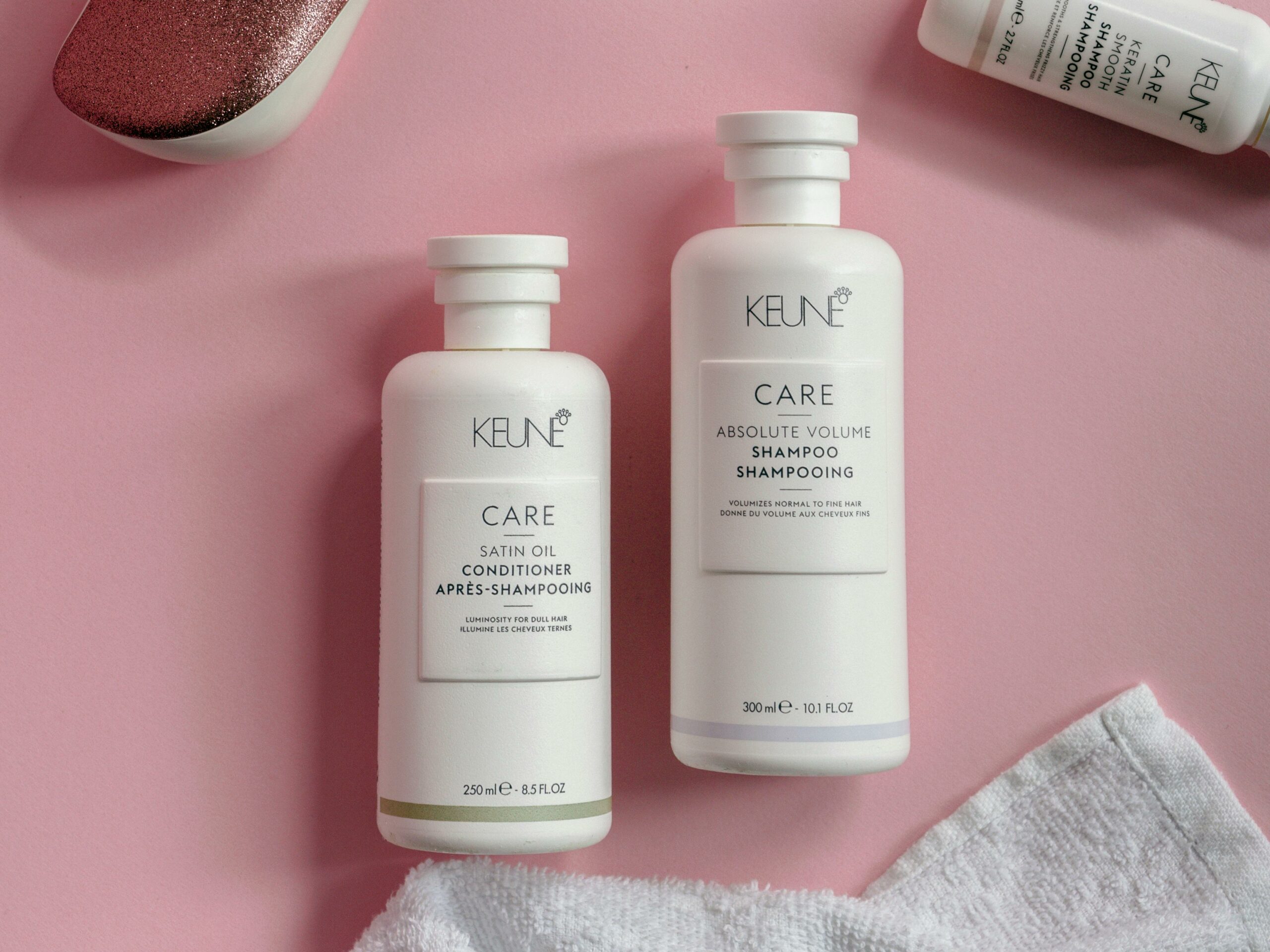 White hair care bottles on a pastel pink surface for a stylish and modern look.